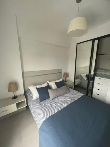 um quarto com uma cama azul e branca e um espelho em DEPTO CON INCREIBLE VISTA!! Y UBICACION!! em Salta