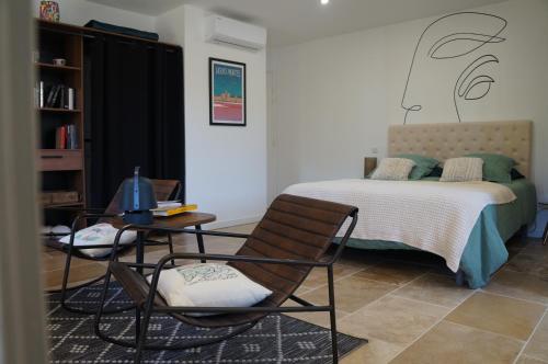 une chambre avec un lit, une table et des chaises dans l'établissement La Suite du Mas Lauseta - clim et park, à Aigues-Mortes