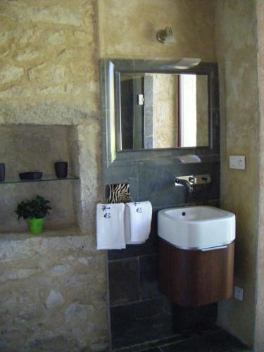 une salle de bain avec un lavabo et un miroir dans l'établissement pigeonnier-four à pain, à Cazals