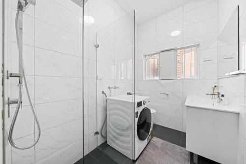 e bagno con doccia, servizi igienici e lavandino. di Burwood City Newly renovated 2 Bed 2 Bath Free Private Parking Big Apt a Sydney