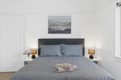 una coperta su un letto con due lampade di Burwood City Newly renovated 2 Bed 2 Bath Free Private Parking Big Apt a Sydney