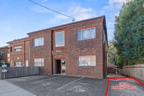 a brick building with a parking space in front of it at Burwood City Newly renovated 2 Bed 2 Bath Free Private Parking Big Apt in Sydney