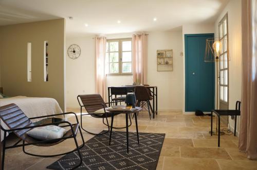 une chambre avec des chaises, une table et un lit dans l'établissement La Suite du Mas Lauseta - clim et park, à Aigues-Mortes