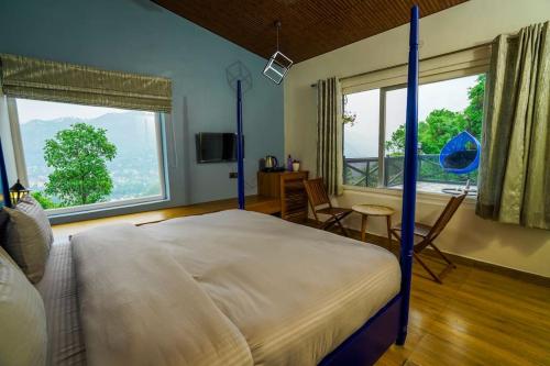 una camera con un letto e una grande finestra di The Apricity Bhimtal a Bhimtal