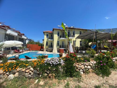 een huis met een zwembad en een tuin met bloemen bij ölüdeniz moonstar in Fethiye