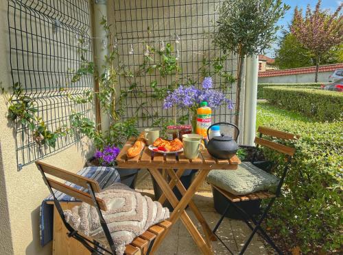 einen Tisch mit einer Schüssel Essen und Blumen darauf in der Unterkunft La Voulzie Appartement - Proche centre avec parking privé in Provins