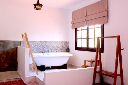 La salle de bains est pourvue d'une baignoire et d'une fenêtre. dans l'établissement Dar Maria - Maison d'hôtes, à Aouchtame
