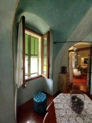 a room with a bed and a window and a table at La Casa Rosa in Pigna