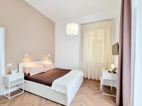 a white bedroom with a bed and a window at Glamour Suite Cagliari in Cagliari