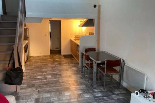 une cuisine avec une table et des chaises dans une pièce dans l'établissement Joli duplex en centre ville de 40m2 climatisé, à Istres