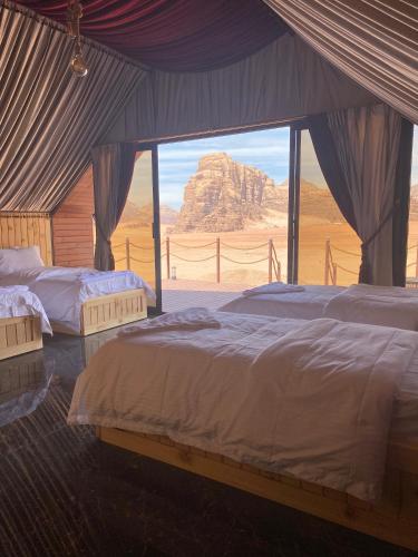 a bedroom with two beds and a view of the desert at Rum Stars Camp in Wadi Rum