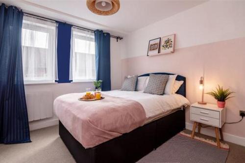 a bedroom with a bed with a tray of fruit on it at Queens House Apartment in Coventry