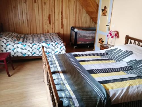 2 camas en una habitación con paredes de madera en Maison de montagne, en Borce
