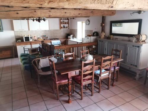 une cuisine et une salle à manger avec une table et des chaises en bois dans l'établissement Maison de montagne, à Borce