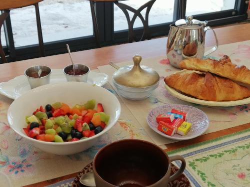 a table with a bowl of fruit and a bowl of bread at La Campagne en Ville in Laragne