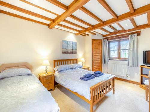 a bedroom with two beds and a tv at The Lodge in Lydney