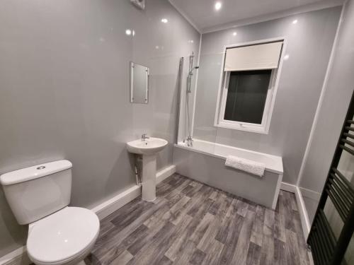 Baño blanco con aseo y lavamanos en Manchester St by Prestige Properties SA en Barrow in Furness