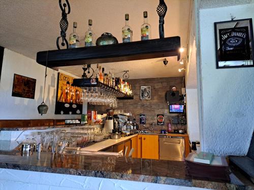 a bar with a counter with bottles on the wall at Blue Mountain Hotel in Afritz