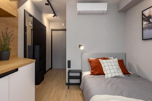 ein Schlafzimmer mit einem Bett mit orangefarbenen Kissen in der Unterkunft Balcia Residence in Riga