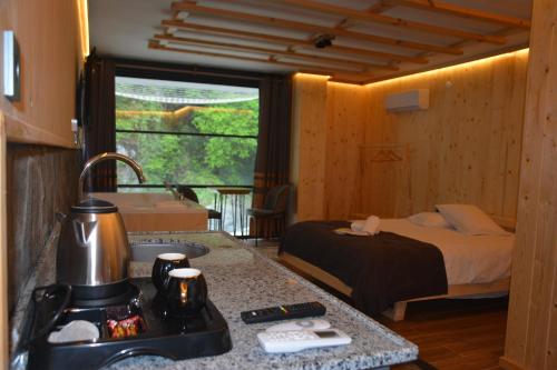 a bedroom with a bed and a kitchen with a sink at DOĞAL SUİT BUNGALOV in Ardeşen