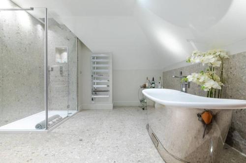 uma casa de banho com um chuveiro e um lavatório branco em Toppesfield Vineyard luxury, contemporary villa - 2 adults em Toppesfield