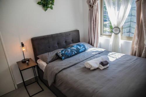 1 cama con 2 toallas y ventana en Roma Guesthouse in the Heart of Lusaka, en Lusaka