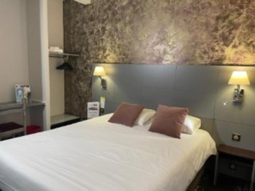 ein Schlafzimmer mit einem großen weißen Bett mit zwei Kissen in der Unterkunft Kyriad Direct Limoges Nord in Limoges