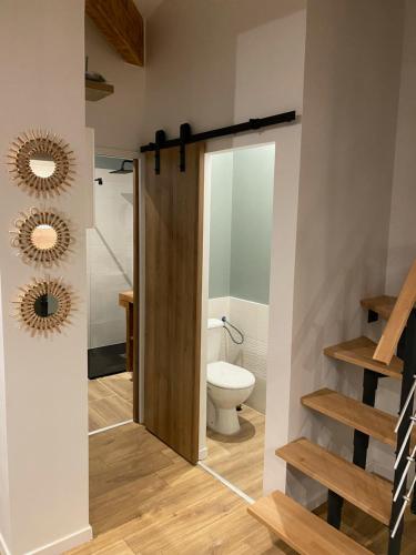 łazienka z toaletą i drewnianymi drzwiami w obiekcie Le Gîte de Maxou w mieście Montauban