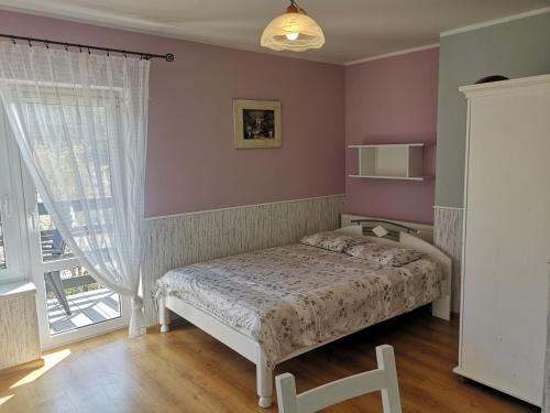 a bedroom with a bed and a window at Pokoje gościnne Bartek in Białogóra