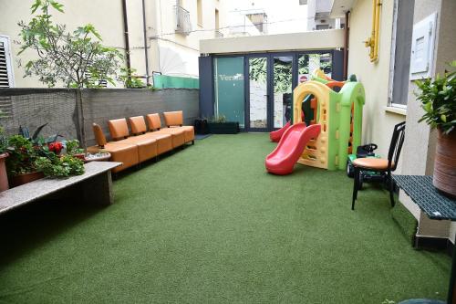 a living room with a playground and a couch at Hotel Okinawa in Rimini