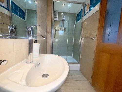 baño con lavabo y ducha con puerta de cristal en Remarkable 1-Bed House NearZip World Snowdonia, en Tanygrisiau