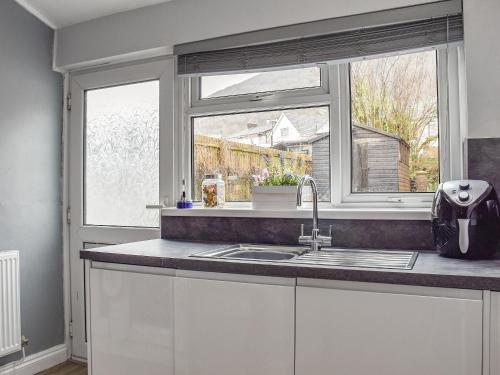 una cucina con lavandino e finestra di Cwmcarn Cottage a Crosskeys
