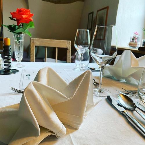 a table with a white table cloth and wine glasses at Landhotel Gasthof Zum Löwen in Rodengo
