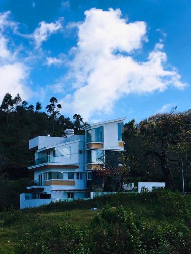 a white building on top of a hill at Salora Kodai in Kodaikānāl