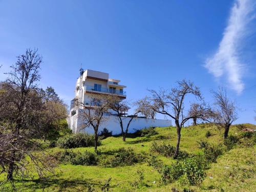 a building on top of a hill with trees at Salora Kodai in Kodaikānāl