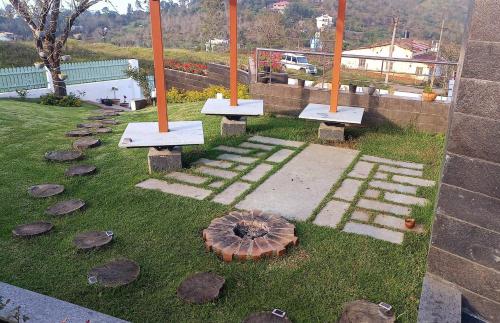 a group of benches sitting on the grass with rocks at Salora Kodai in Kodaikānāl