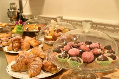 a table with plates of pastries and trays of pastries at Hotel Okinawa in Rimini