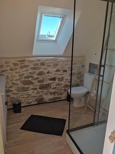 een badkamer met een toilet en een raam aan de muur bij Gîte Le Cabestan à la mer Lingreville in Lingreville