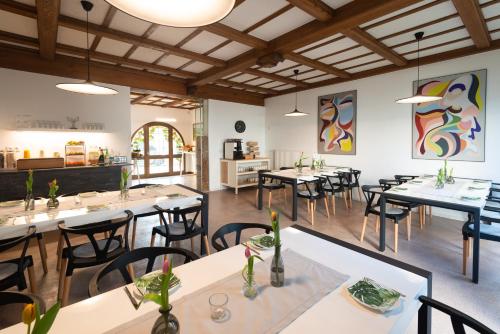 ein Restaurant mit Tischen und Stühlen in einem Zimmer in der Unterkunft Moselweingut & Gästehaus Hubertushof in Trittenheim