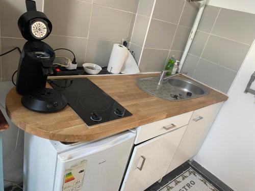 une cuisine avec un évier et un plan de travail dans l'établissement STUDIO COSY climatisé 5 mn de la gare, à Sète