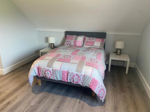 sypialnia z łóżkiem i dwoma stołami z lampkami w obiekcie Castle View Rooms w mieście Liscannor