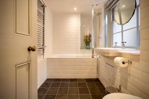 a bathroom with a tub and a sink and a toilet at Kings Cross, self-contained house & private garden in London