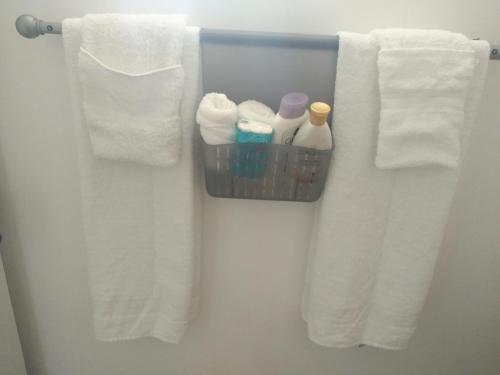 ein Bad mit weißen Handtüchern und einem Korb mit Pflegeprodukten in der Unterkunft Splendid Sensation in Florence Hall