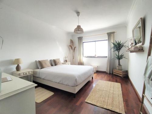 biała sypialnia z łóżkiem i oknem w obiekcie Villa Intuitiva w mieście Lourinhã