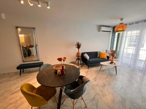 ein Wohnzimmer mit einem Tisch, Stühlen und einem Sofa in der Unterkunft Casa de Tres Hermanos in the heart of Athens in Athen