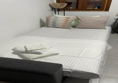 ein Bett mit weißer Bettwäsche und Kissen darauf in der Unterkunft Symi Breeze villa in Symi