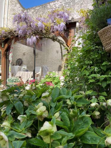 a garden with purple flowers on a building at Hotel de la Sologne in Beaugency