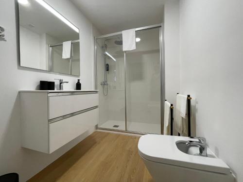 a white bathroom with a sink and a shower at Living PDL 1 in Ponta Delgada