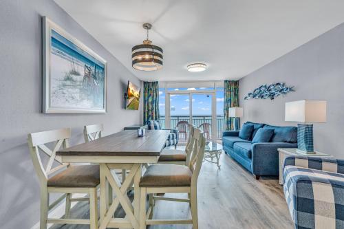 a dining room and living room with a table and chairs at Beach-side Condo w Pools in Myrtle Beach