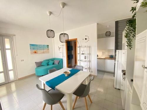 cocina y sala de estar con mesa y sillas en Vista Azzurra en Marina di Modica